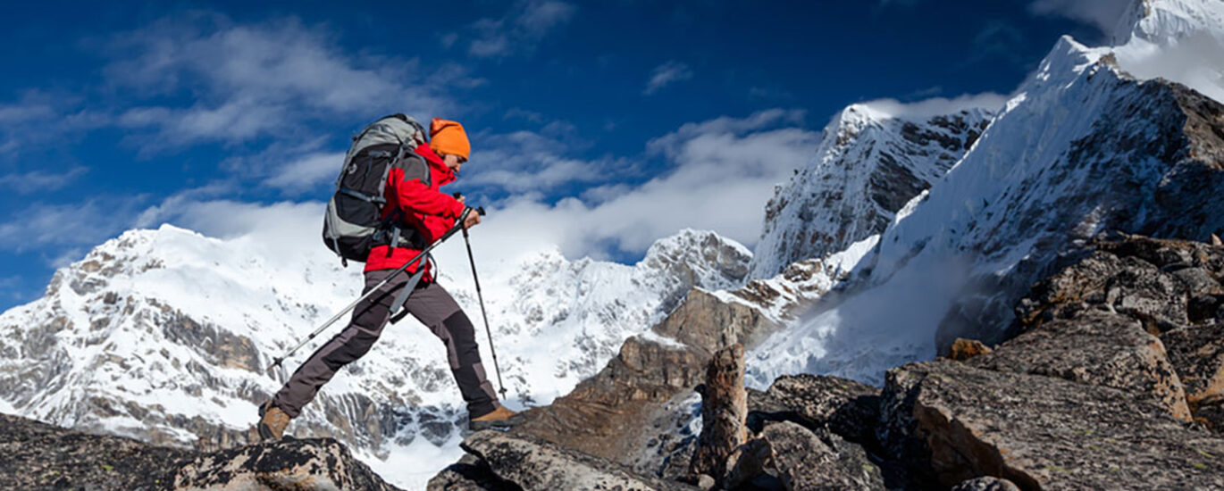 A man confidently hiking up a mountain trail while carrying a backpack, emphasizing the connection between outdoor activities and altitude sickness. Proper awareness, acclimatization, and prevention strategies are essential to minimize the risk of altitude sickness during high-altitude hikes. Discover altitude sickness tips and treatment options at North Harrow Pharmacy for a safe mountain adventure.