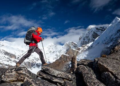 A man confidently hiking up a mountain trail while carrying a backpack, emphasizing the connection between outdoor activities and altitude sickness. Proper awareness, acclimatization, and prevention strategies are essential to minimize the risk of altitude sickness during high-altitude hikes. Discover altitude sickness tips and treatment options at North Harrow Pharmacy for a safe mountain adventure.