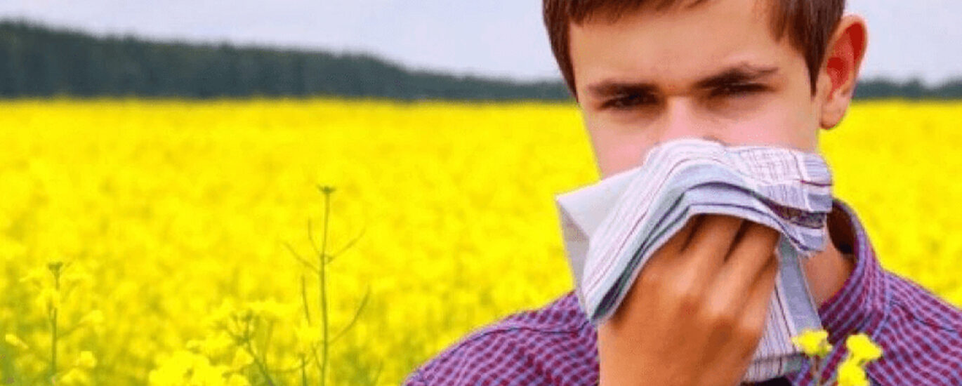 Illustration depicting a boy surrounded by hay, experiencing symptoms of allergy such as sneezing and itching