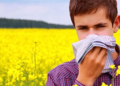 Illustration depicting a boy surrounded by hay, experiencing symptoms of allergy such as sneezing and itching