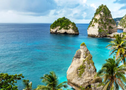 Breathtaking ocean view in Bali - Crystal clear blue waters with palm trees lining the shore, offering a serene and picturesque scene in Bali, the perfect honeymoon destination.