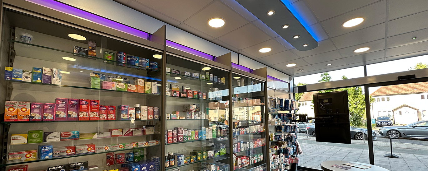 A diverse array of over-the-counter (OTC) medicines neatly arranged on a pharmacy shelf in North Harrow Pharmacy & Travel Clinic. The medications are packaged in various colors and sizes, representing a range of health solutions. Pill bottles and boxes prominently feature well-known brands, and labels indicate common uses such as pain relief, allergy treatment, and cold remedies. The display conveys the accessibility and variety of OTC medications for managing a spectrum of health needs.