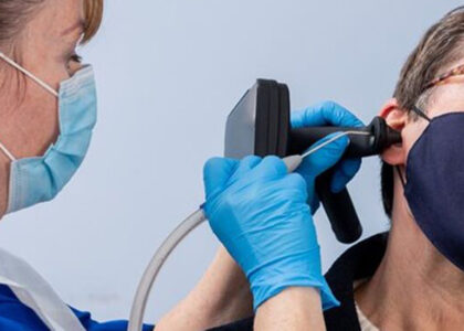 An earwax removal specialist using Tympa Health equipment to remove earwax using microsuction technique.